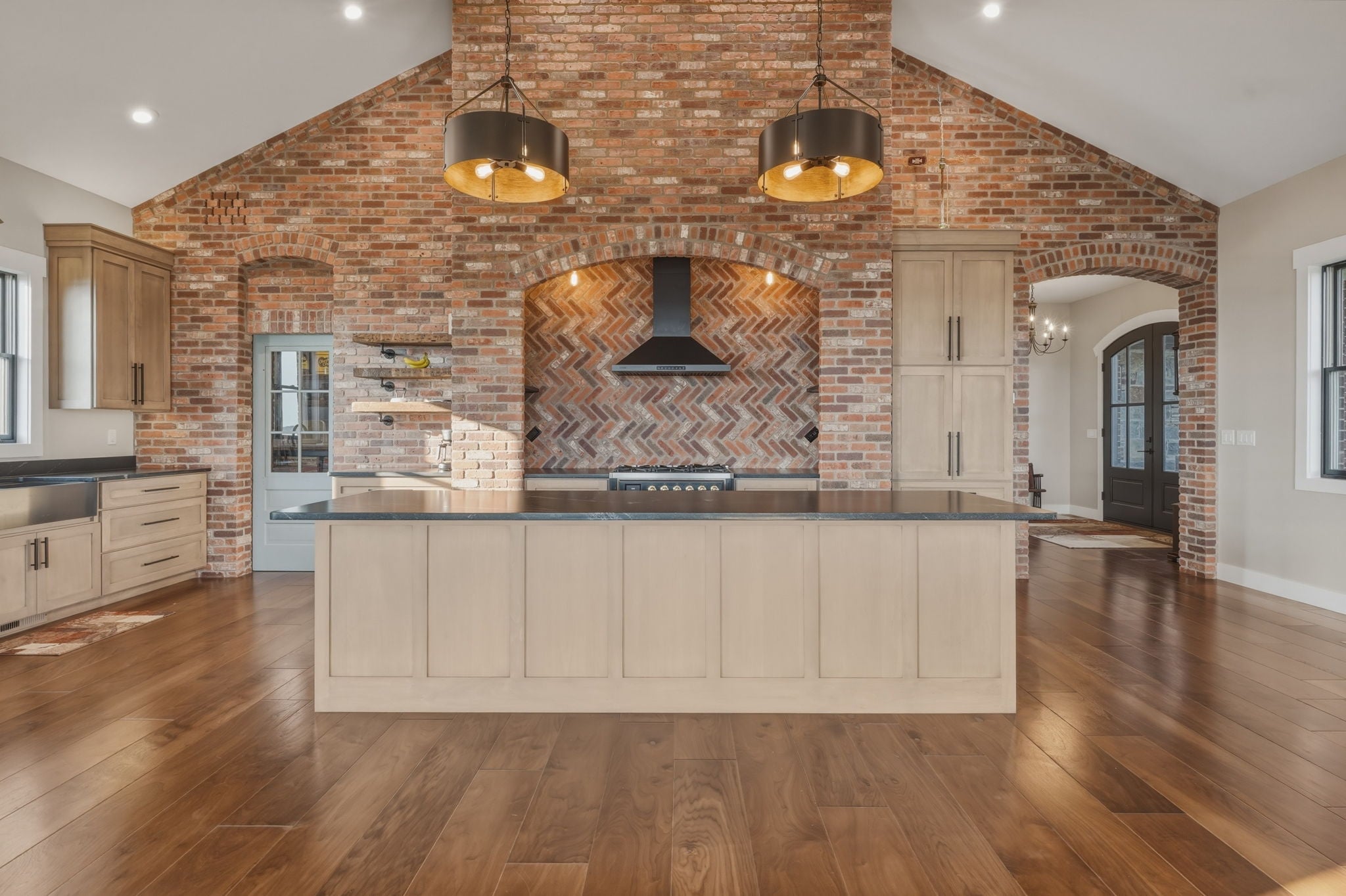 Kitchen island with brick herringbone range hood