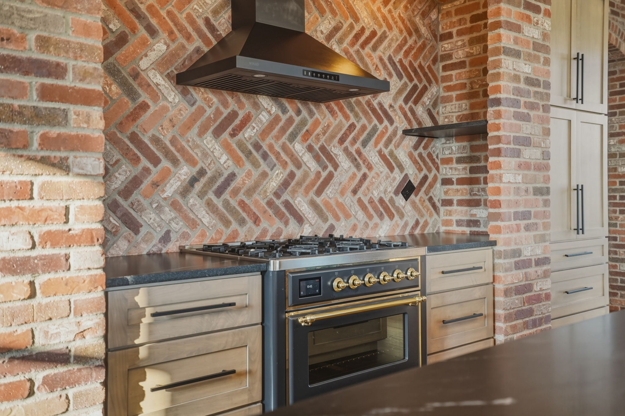 Close-up of brick herringbone range hood over professional range