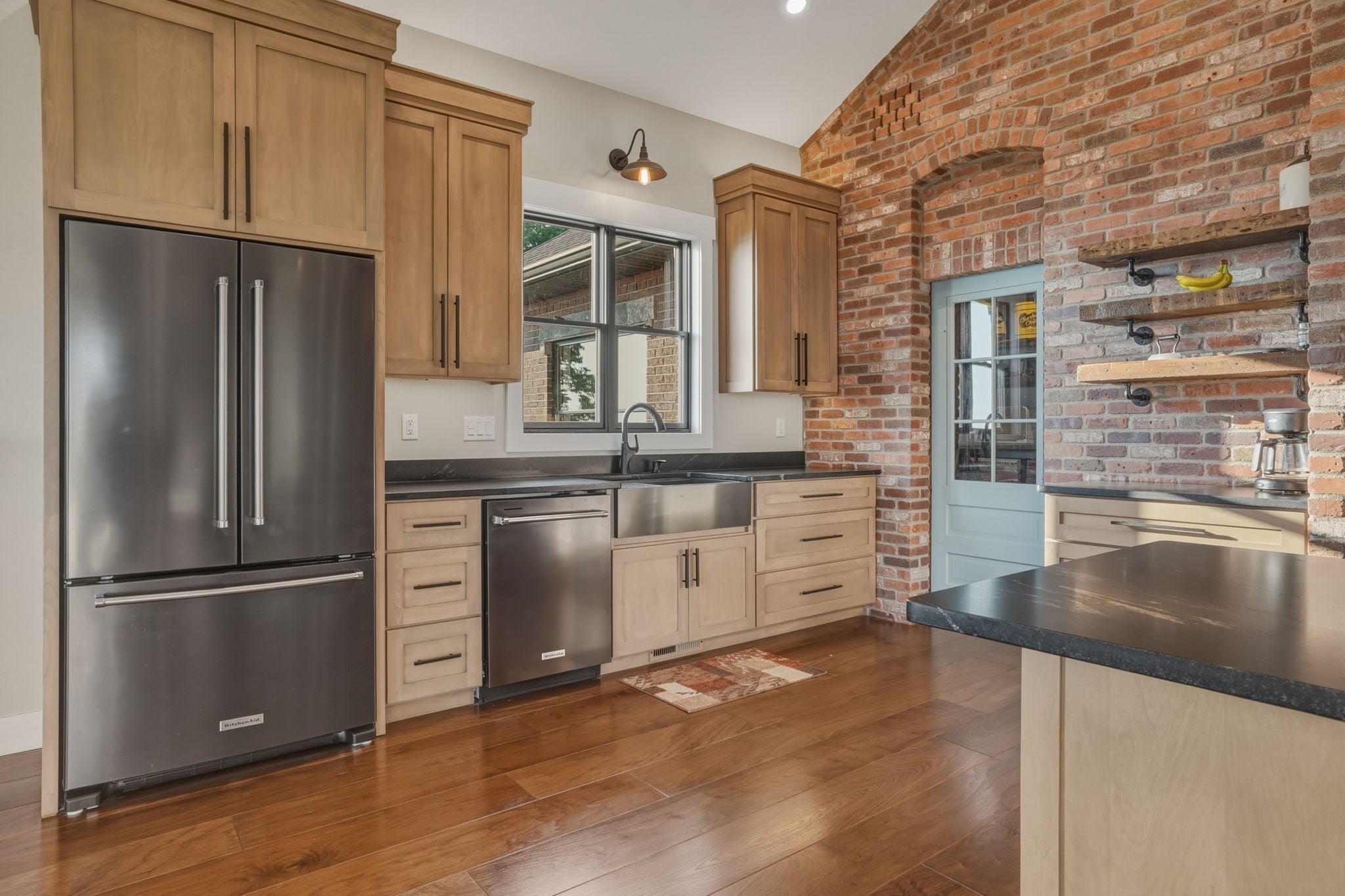 Kitchen wide shot with cabinetry and stainless appliances