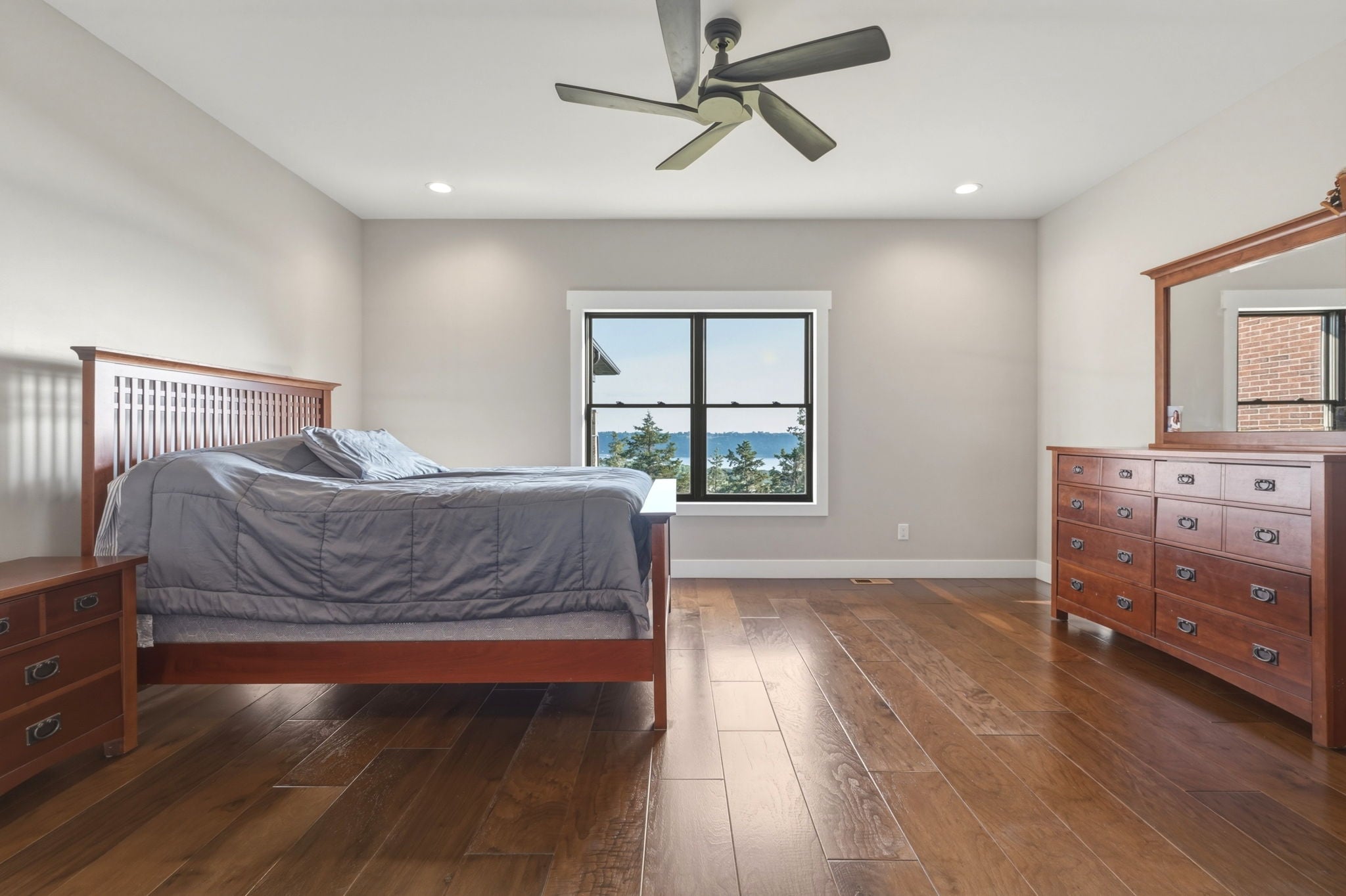 Primary bedroom with water view through large windows