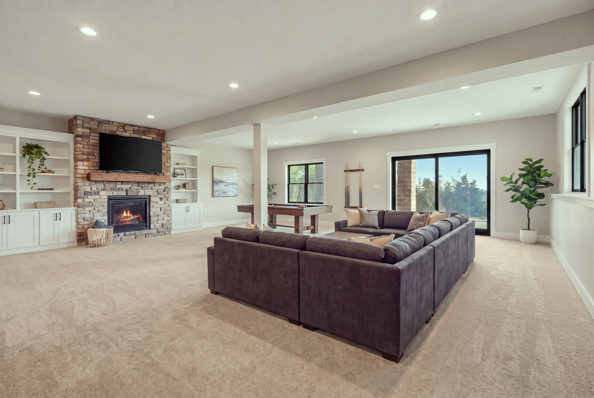 Finished lower-level living space with fireplace and pool table